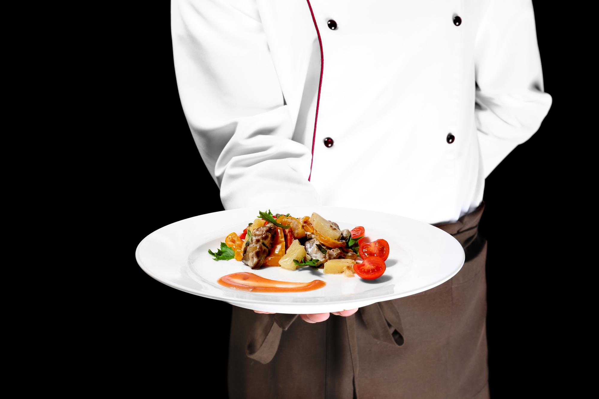 Chef presenting plated course in refined setting